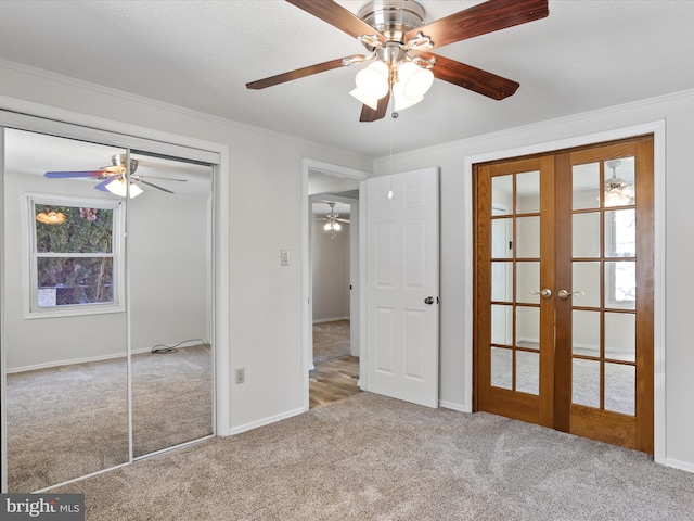 unfurnished bedroom with light colored carpet, ceiling fan, ornamental molding, french doors, and multiple windows