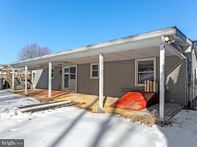 snow covered rear of property featuring ceiling fan