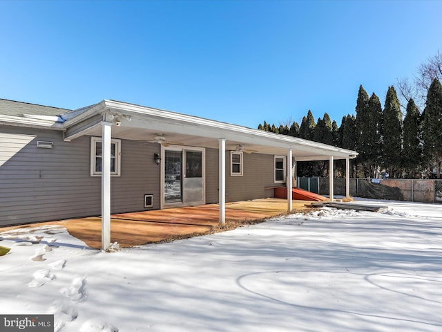 snow covered house featuring ceiling fan