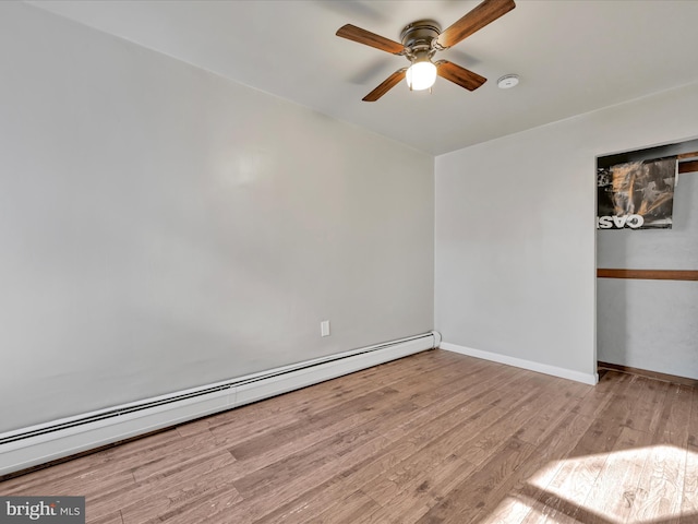 spare room with a baseboard heating unit, ceiling fan, and light hardwood / wood-style flooring