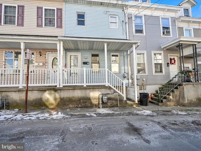 townhome / multi-family property featuring a porch and cooling unit