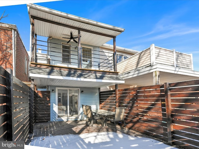 back of property with a balcony and ceiling fan