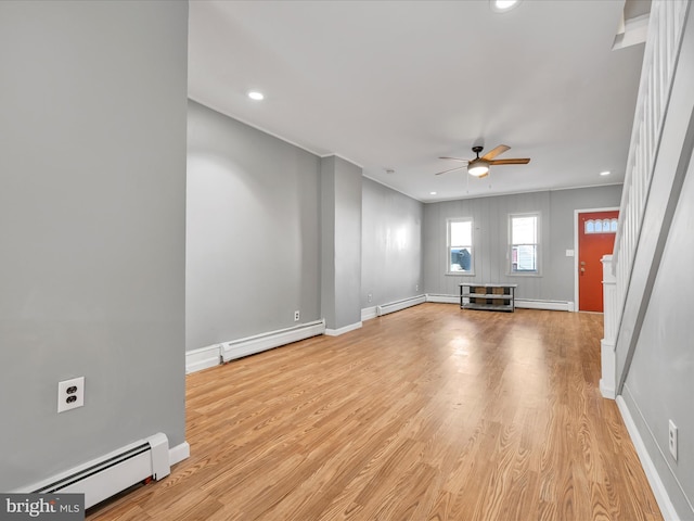 unfurnished living room featuring a baseboard heating unit, ceiling fan, and light hardwood / wood-style floors