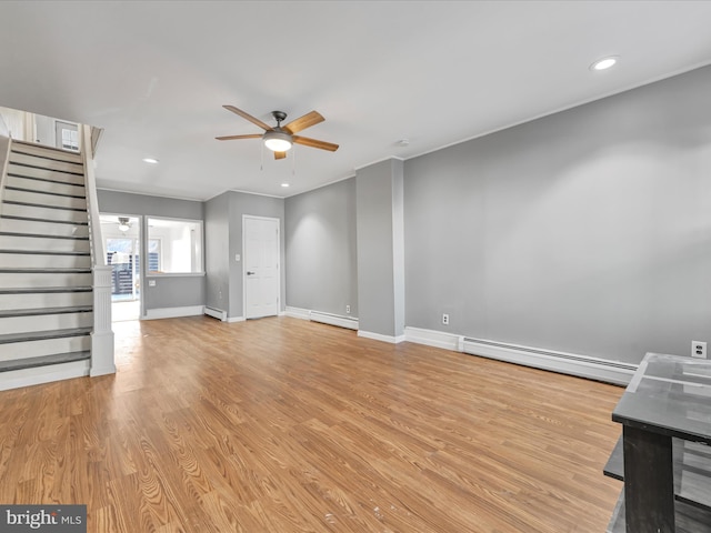 unfurnished living room featuring a baseboard heating unit, light wood-type flooring, and ceiling fan