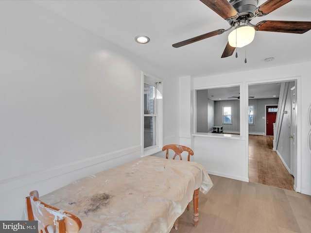 dining area featuring hardwood / wood-style flooring, a baseboard heating unit, and ceiling fan