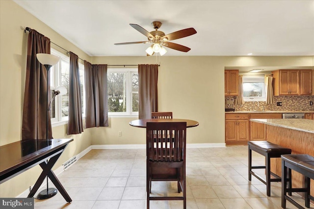 tiled dining area with sink and ceiling fan