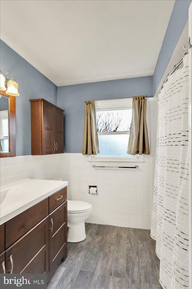 bathroom featuring tile walls, a wealth of natural light, wood-type flooring, and vanity