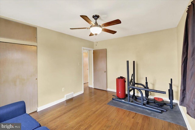 exercise area featuring wood-type flooring and ceiling fan