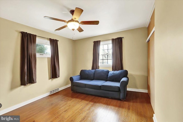 living area featuring hardwood / wood-style floors and ceiling fan