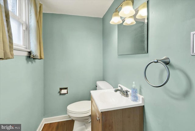 bathroom featuring toilet, wood-type flooring, and vanity