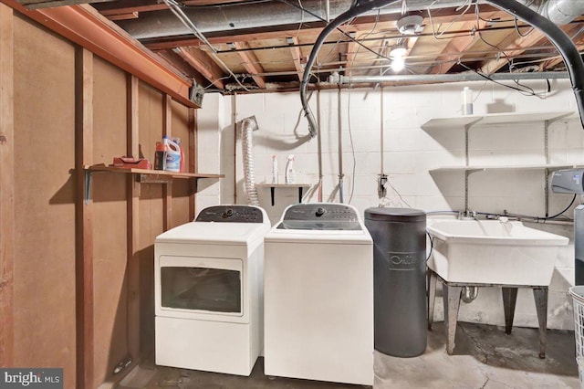 clothes washing area featuring washer and clothes dryer and sink