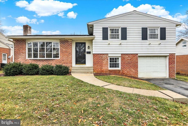 split level home featuring a garage and a front lawn