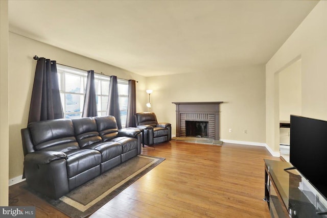 living room featuring wood-type flooring and a fireplace