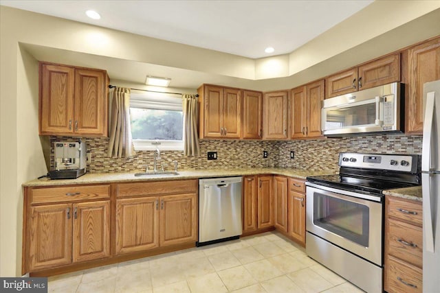 kitchen with stainless steel appliances, decorative backsplash, and sink