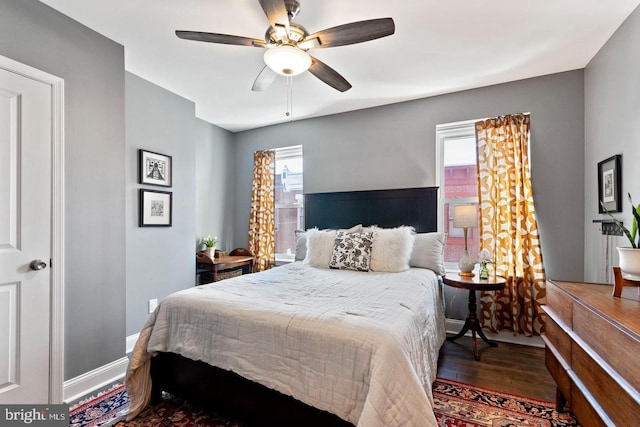 bedroom with multiple windows, ceiling fan, and dark hardwood / wood-style floors