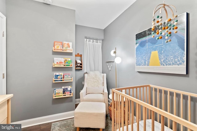 bedroom with hardwood / wood-style flooring and a crib