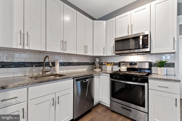 kitchen featuring appliances with stainless steel finishes, decorative backsplash, dark hardwood / wood-style floors, sink, and white cabinetry