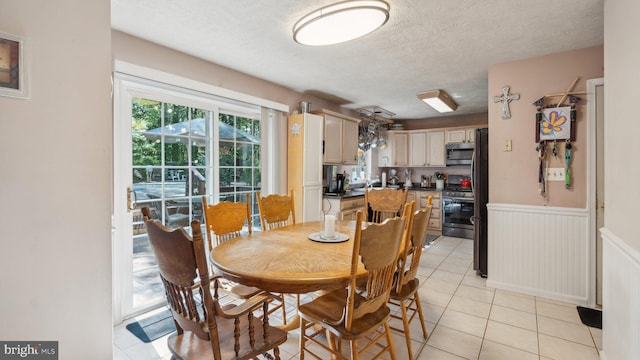 dining space featuring a textured ceiling and light tile patterned flooring