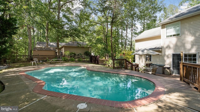 view of pool featuring area for grilling and a wooden deck