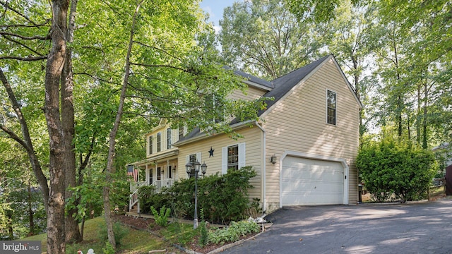 view of home's exterior with a garage and covered porch