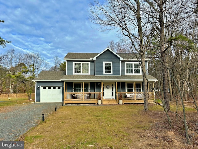 view of front of property featuring a front yard, a garage, and covered porch