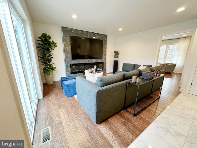 living room with a large fireplace and hardwood / wood-style flooring