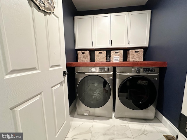 laundry area featuring washing machine and dryer and cabinets