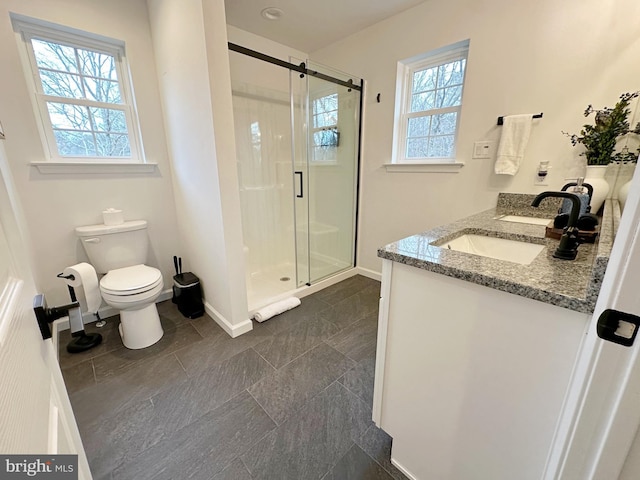 bathroom with toilet, a wealth of natural light, walk in shower, and vanity