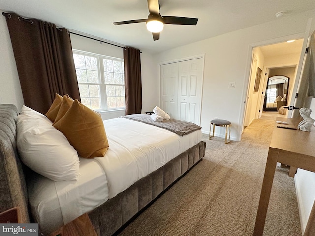 bedroom featuring a closet, ceiling fan, and light colored carpet