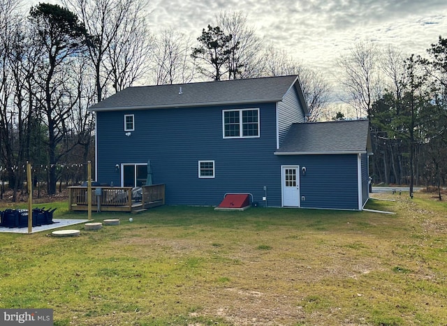 back of property featuring a deck and a lawn