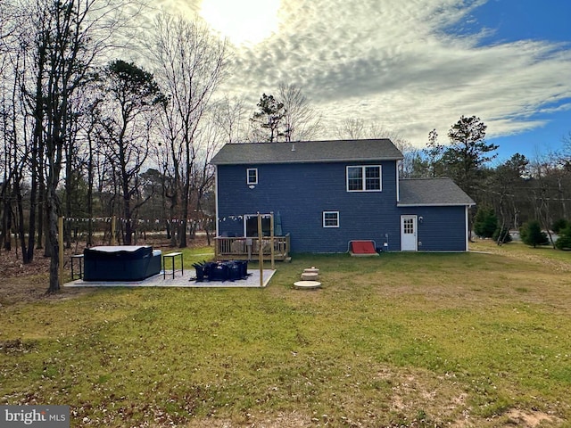 back of house with a patio, a lawn, a hot tub, and a wooden deck