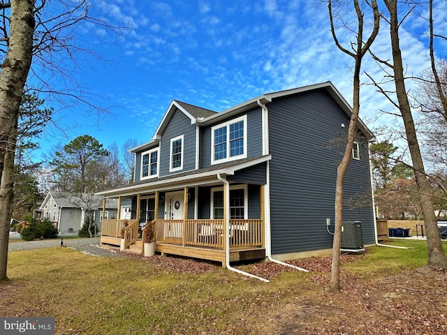 view of front facade featuring central AC, a front yard, and covered porch