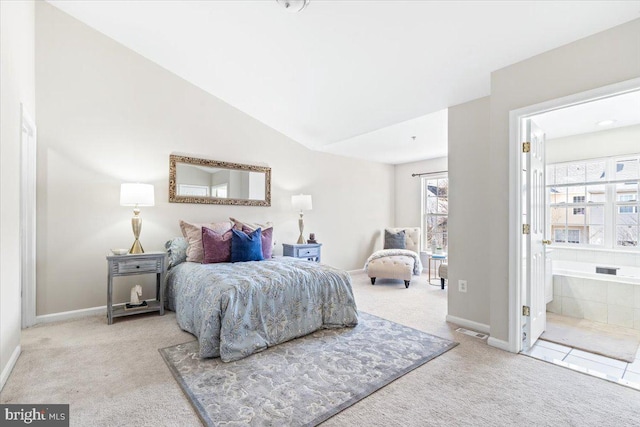 carpeted bedroom featuring vaulted ceiling and ensuite bath