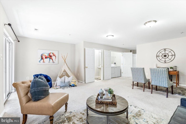 living room featuring light carpet and washer and clothes dryer