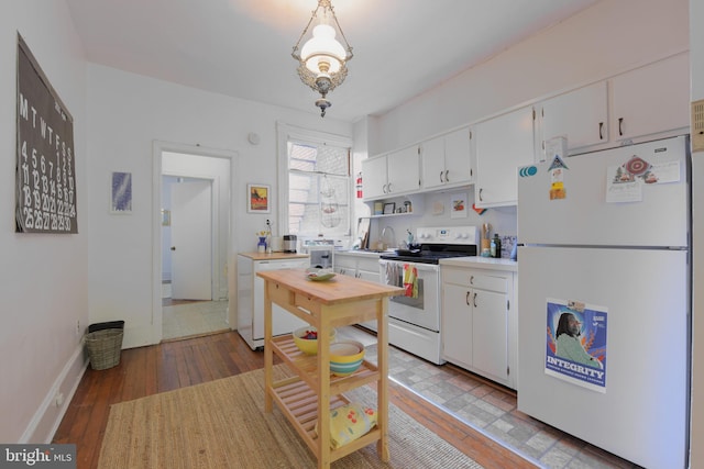 kitchen featuring hardwood / wood-style floors, light countertops, white appliances, and white cabinetry