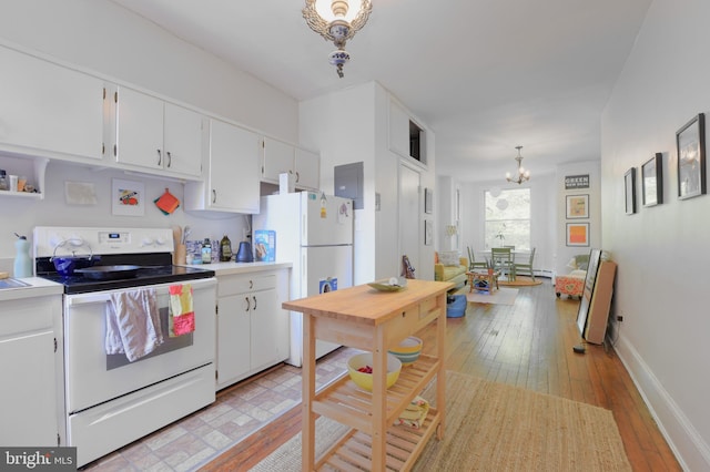 kitchen with light wood finished floors, light countertops, white appliances, and white cabinetry