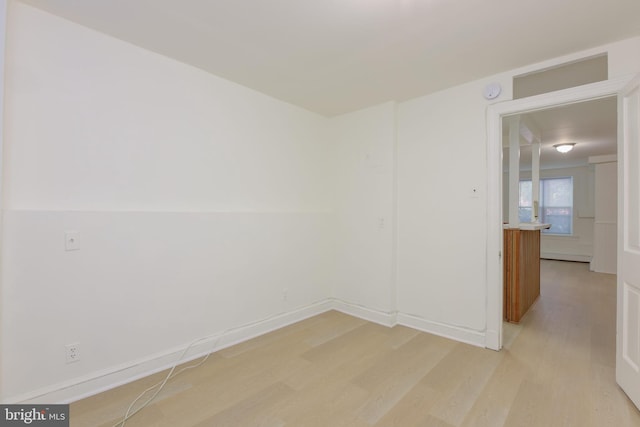 empty room with light wood finished floors and baseboards