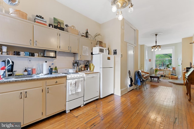 kitchen with light countertops, white appliances, a sink, and backsplash