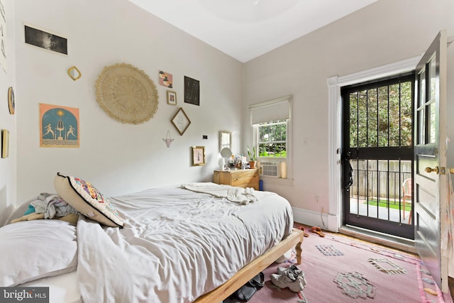 bedroom with baseboards, access to outside, and wood finished floors