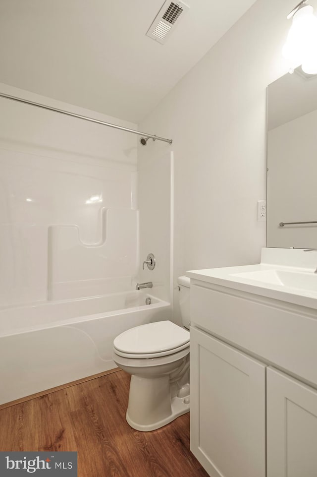 full bathroom featuring toilet, wood-type flooring, shower / washtub combination, and vanity