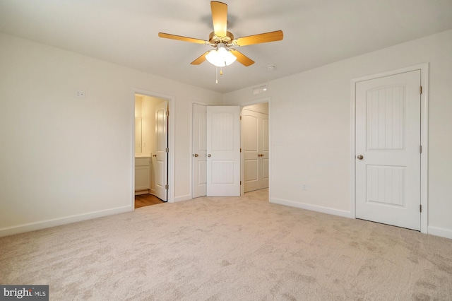 unfurnished bedroom featuring light colored carpet, ceiling fan, and connected bathroom