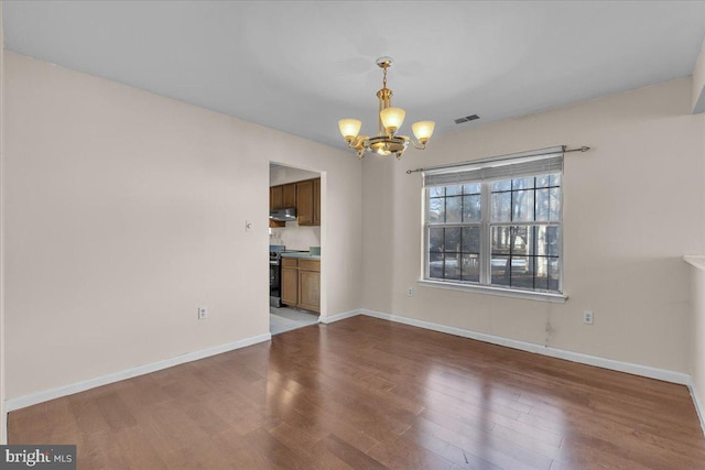 unfurnished dining area featuring hardwood / wood-style flooring and a chandelier