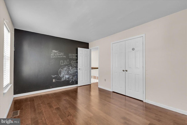 unfurnished bedroom with wood-type flooring and a closet