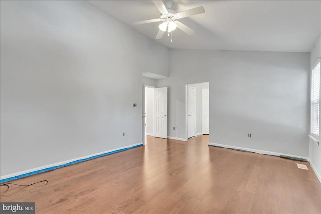 unfurnished room featuring hardwood / wood-style flooring, high vaulted ceiling, and ceiling fan