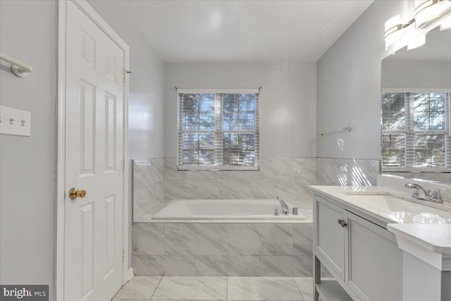 bathroom featuring vanity and tiled bath