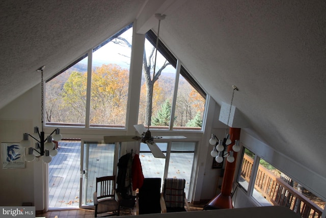 living room featuring ceiling fan, a textured ceiling, and vaulted ceiling