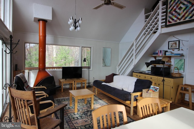 living room with ceiling fan with notable chandelier and high vaulted ceiling