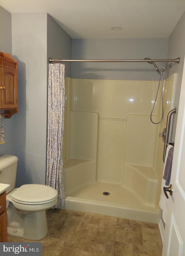 bathroom with vanity, toilet, and walk in shower