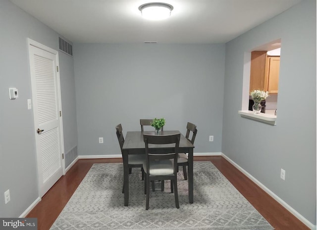 dining space with dark hardwood / wood-style flooring