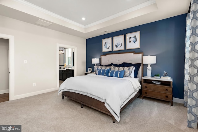 bedroom featuring light colored carpet, ensuite bathroom, a raised ceiling, and crown molding